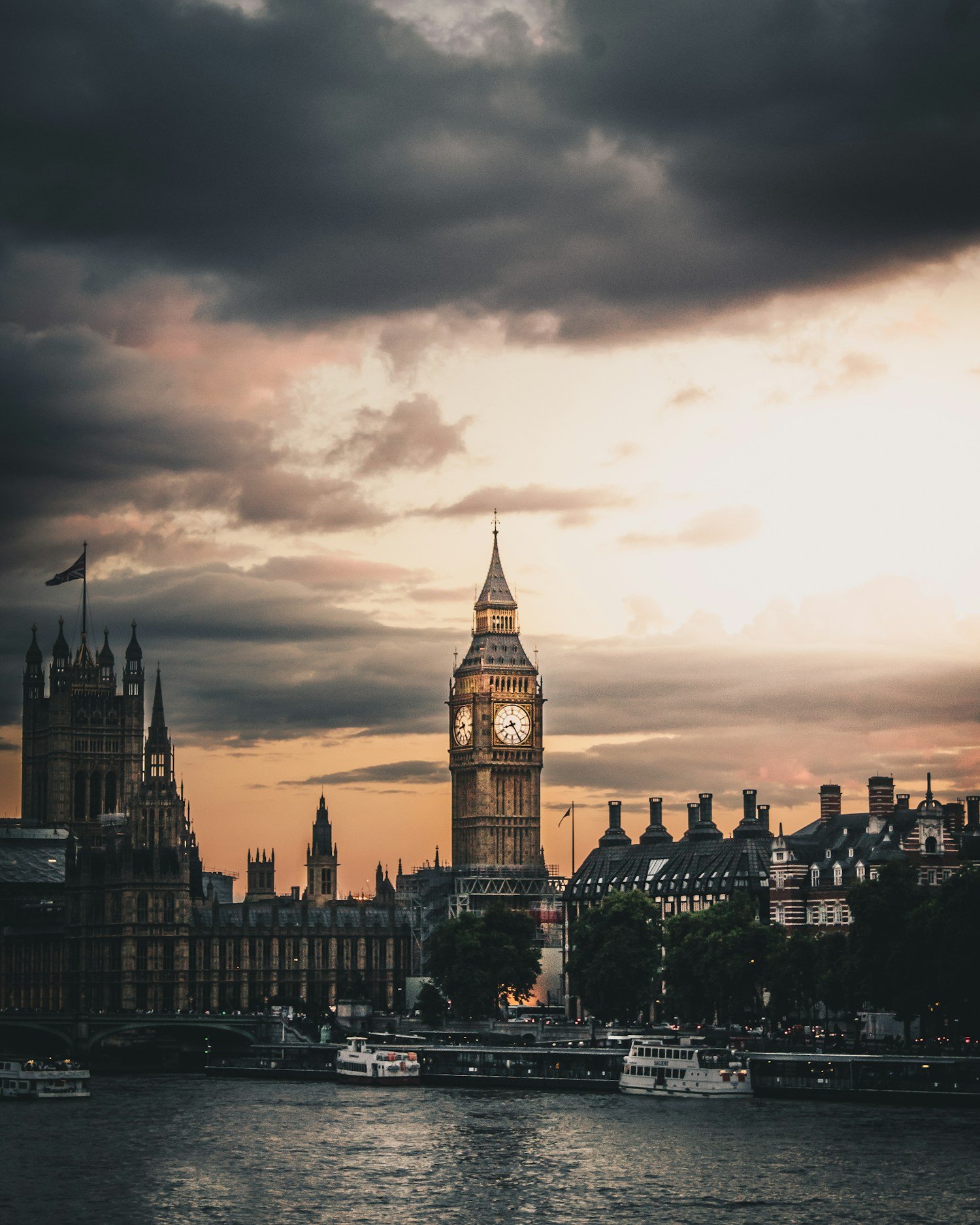 Big Ben and the Houses of Parliament beside the River Thames at sunset.